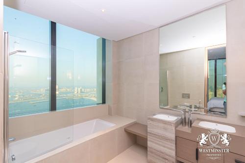 a bathroom with a tub and a sink and a window at Westminster JBR in Dubai