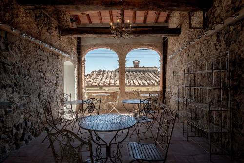 a table and chairs in a room with a window at Palazzo Giusti, Understated Luxury with a Welcoming Ambience on the Hills of Lucca in Pescaglia