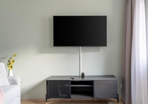 a living room with a tv on a wall at Limehome Magdeburg Breiter Weg in Magdeburg