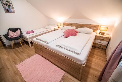 a small bedroom with two beds and a chair at Guesthouse Leski Dvor in Lesce