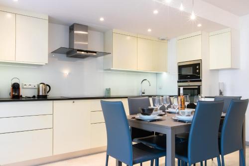 une cuisine avec une table et des chaises bleues dans l'établissement Renovated 2-Br Apartment with Terrace and Pool, à Cannes
