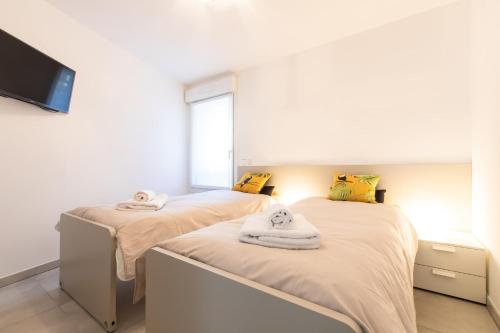 une chambre avec deux lits avec des serviettes dessus dans l'établissement Renovated 2-Br Apartment with Terrace and Pool, à Cannes