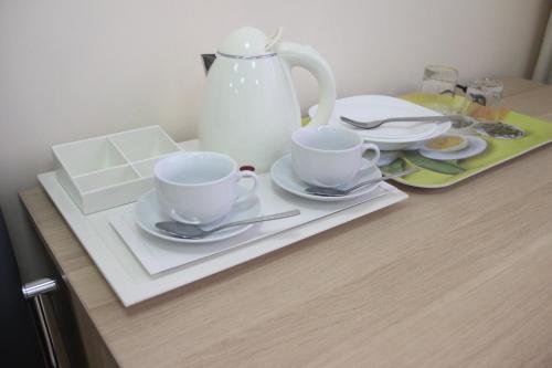 uma mesa com duas chávenas e pratos e um bule de chá em Sokol Hotel em Sochi