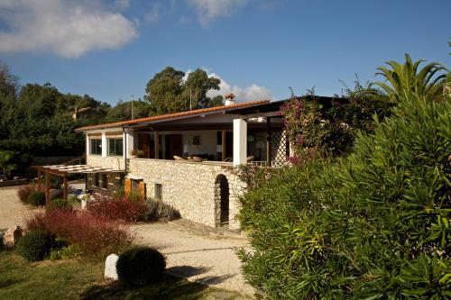 ein Haus mit einer Steinfassade und einem Garten in der Unterkunft Residence Les Oliviers in Porto Azzurro