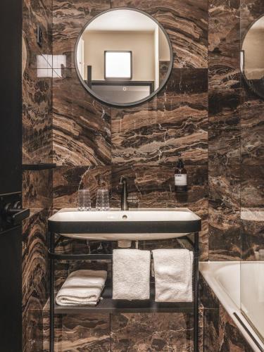 une salle de bain avec un lavabo et un miroir dans l'établissement Maisons du Monde Hôtel & Suites - La Rochelle Vieux Port, à La Rochelle