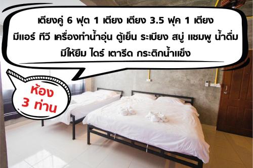 two beds in a room with the words kyi and a text overlay at The Sky Loft Hotel in Pathum Thani