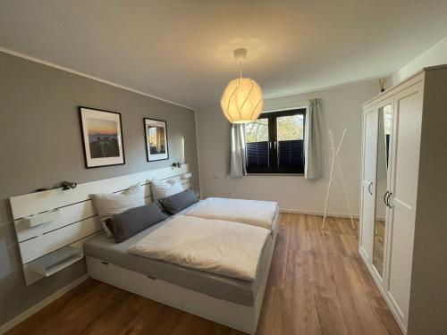 a bedroom with a white bed and a window at Ferienwohnung di Simoni in Bad Laasphe