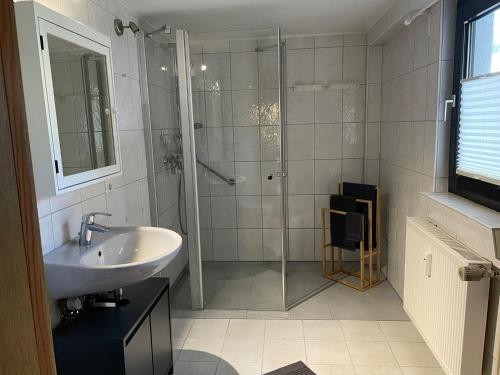 a bathroom with a glass shower and a sink at Ferienwohnung di Simoni in Bad Laasphe