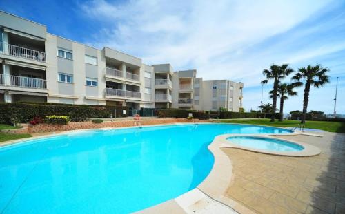 une grande piscine en face d'un bâtiment dans l'établissement Apartamento con piscina en una preciosa playa, à Alcossebre