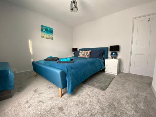 a bedroom with a blue bed with a blue blanket at Shelley Beach in Deal