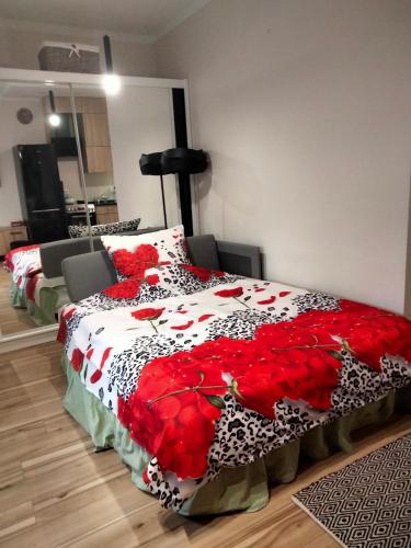 a bedroom with a bed with a red and white blanket at Uroczy Loft in Częstochowa