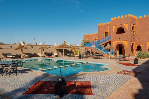 a swimming pool in a courtyard with a building at Kasbah Hotel Ziz Palace Rissani in Rissani