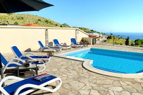 IvanicaにあるLuxury Villa Layla with private pool near Dubrovnikのラウンジチェアとパラソル付きのスイミングプールを併設しています。