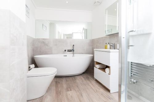 a bathroom with a tub and a toilet and a sink at Elizabeth Flat 5 - By Luxury Apartments in Cheltenham