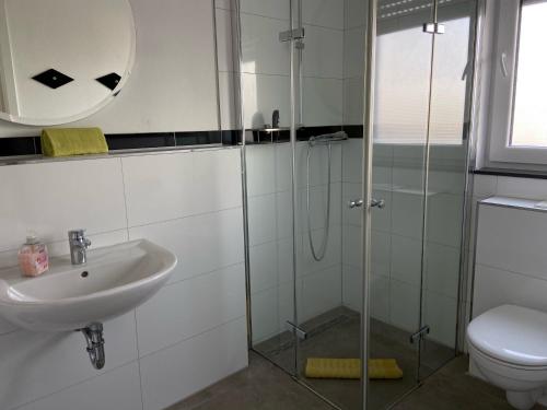 a bathroom with a toilet, sink, and shower at Aparthotel Magnolia in Oberursel