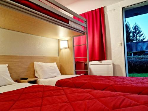 a hotel room with two beds and a window at Premiere Classe Honfleur in Honfleur