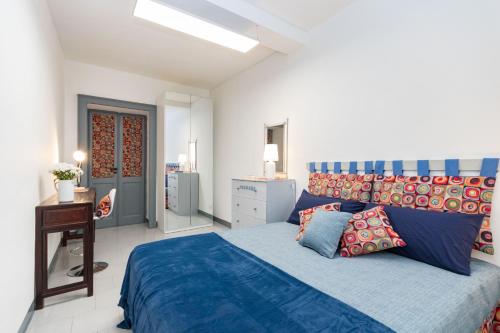 Schlafzimmer mit einem blauen Bett und einem Schreibtisch in der Unterkunft Casa Lagrange by Wonderful Italy in Turin