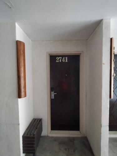 a hallway with a door with a bench in front of it at Buluh Inn @ Gold Coast Morib in Banting