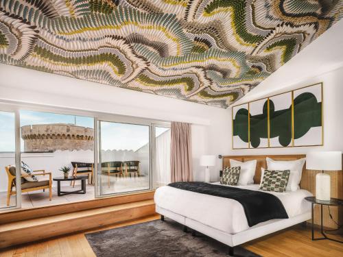 1 dormitorio con cama grande y ventana grande en Maisons du Monde Hôtel & Suites - La Rochelle Vieux Port en La Rochelle