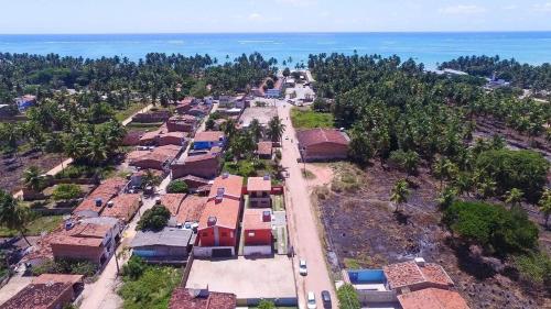 uma vista aérea de uma aldeia com o oceano em Casa Lua Cheia na Praia de Peroba, Maragogi em Maragogi