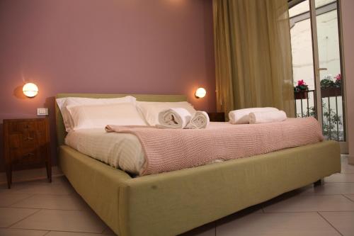 uma cama com duas toalhas num quarto em Soraya em Nápoles