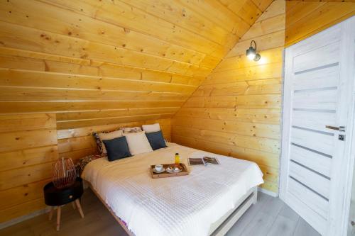 1 dormitorio con 1 cama en una cabaña de madera en Sielanka Mazurska/Mazury en Lepaki Wielkie