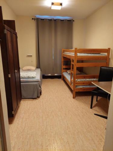 a small room with two bunk beds and a desk at Birkagårdens Vandrarhem in Åled