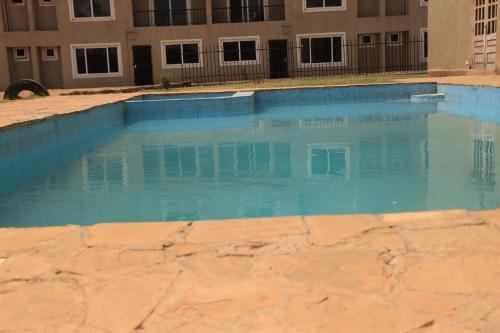 une piscine d'eau bleue devant un bâtiment dans l'établissement Kay Homes, à Eldoret