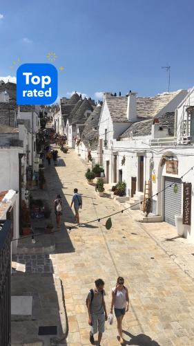 a group of people walking down a street at Noù la tua casa in Puglia in Alberobello