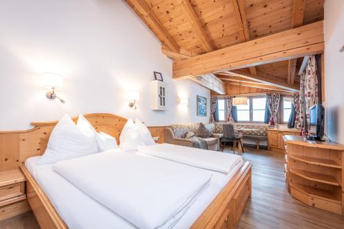 a bedroom with a large bed and a living room at Adults Only Boutique-Hotel Unterlechner in Sankt Jakob in Haus