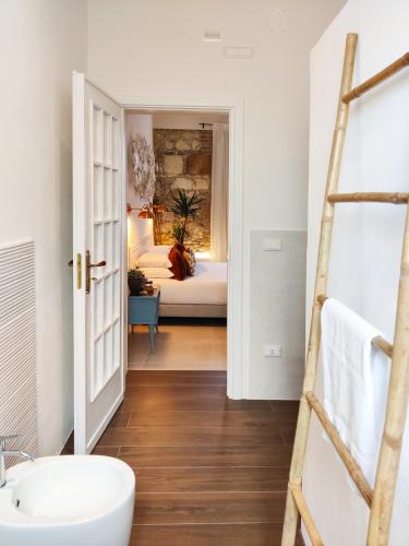 a bathroom with a sink and a bedroom with a bed at Calamùrn Ortigia in Siracusa