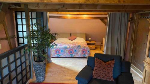 ein Schlafzimmer mit einem Bett und einem Stuhl in einem Zimmer in der Unterkunft Ferienwohnung Kunstscheune Mosel in Raversbeuren