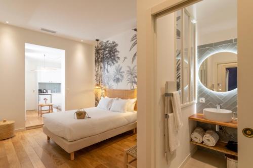 een slaapkamer met een bed en een badkamer met een wastafel bij Les Clés Secrètes in Sète
