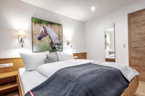 a bedroom with a bed with a painting of a horse at Bergchalet Haflingerherz in Wenns