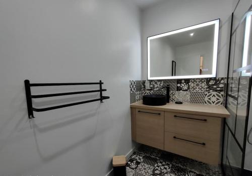 a bathroom with a sink and a mirror at Gîte "La bulle de Léna" avec petit-déjeuner garage et parking in Flavigny