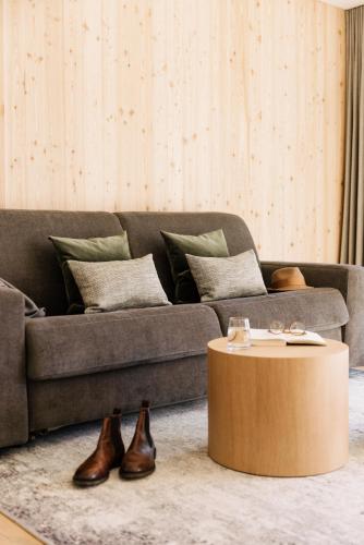 a living room with a couch and a coffee table at Lacumontes Lake View Apartments in Curon Venosta
