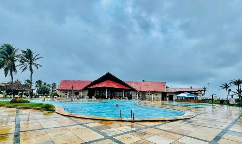 een zwembad van het resort met een gebouw op de achtergrond bij Apartamento Aquaville Resort in Aquiraz