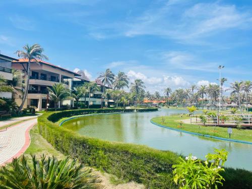 een rivier in een park met palmbomen en gebouwen bij Apartamento Aquaville Resort in Aquiraz