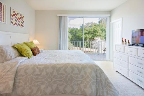 a bedroom with a bed and a television and a balcony at Serenity Resort 3 Bedroom Vacation Townhome with Pool (2008) in Clermont