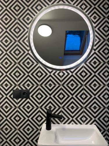 a bathroom with a mirror and a sink at Sangrita Nida ADULTS ONLY in Nida