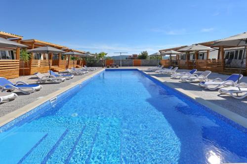 una piscina con tumbonas y una piscina en Poolside Mobile Home en Turanj