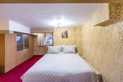 sypialnia z dużym łóżkiem i żółtą tapetą w obiekcie Top Center Vintage Sofia Condo w mieście Sofia