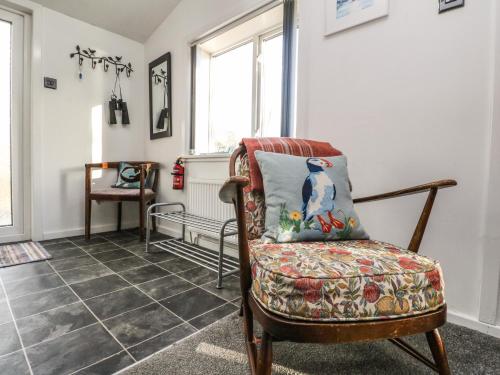 a room with a chair with a pillow on it at Kelpie in Lochgilphead