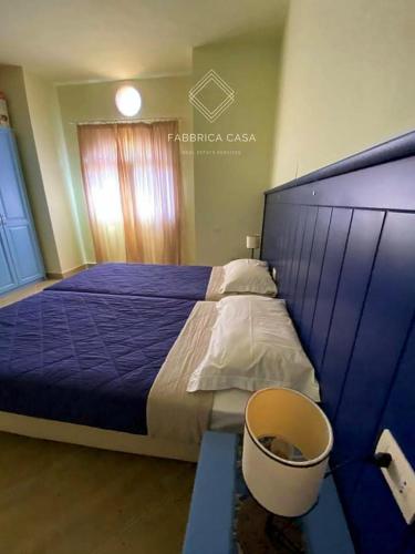 a bedroom with a blue bed with a bucket next to it at FabbricaCasa Sea Front Villa, Oriental Coast in Marsa Alam City