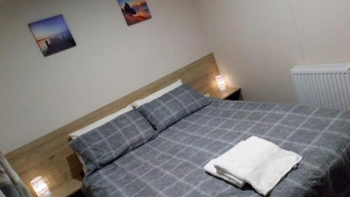 a bedroom with a blue bed with two towels on it at Home from home in Hastings