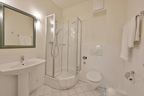 een badkamer met een douche, een toilet en een wastafel bij Strandnahe Ferienwohnung 6 Villa Celia in Ostseebad Sellin
