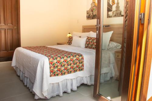 a bedroom with a bed and a mirror at Hotel Casa La Fe in Cartagena de Indias