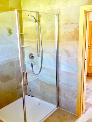 a shower with a glass door in a bathroom at Apartment Sonnenfeld in Samerberg