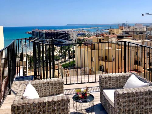 a balcony with two chairs and a table and the ocean at View 4 U Apartment - Alicante in Alicante