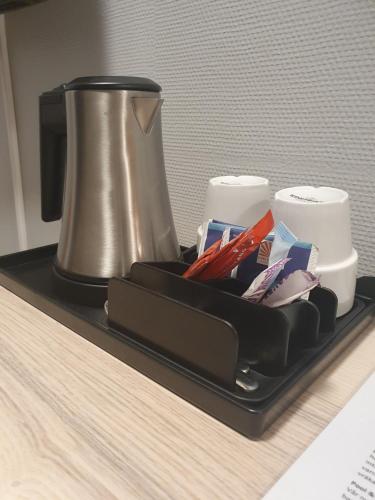 a tray with a coffee maker and cups on a counter at Karlskoga Hotell & Konferens in Karlskoga